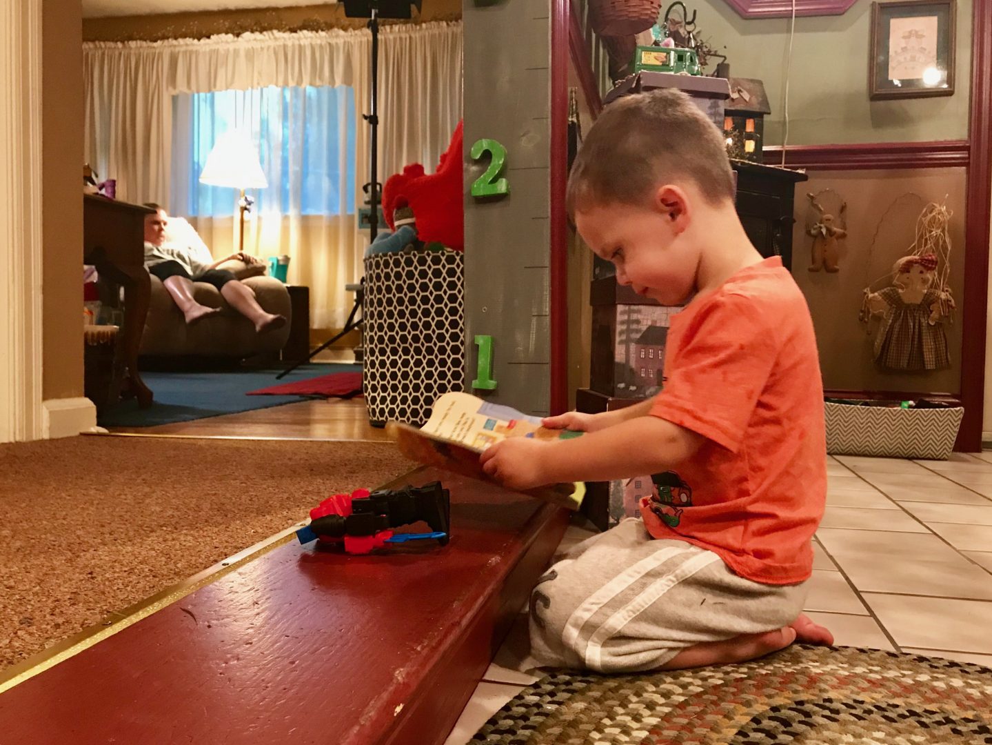 Carson Cox reads a book on the floor of his grandmother's home in Middletown. His mother, Elizabeth Loranzo, died of an overdose in 2017.