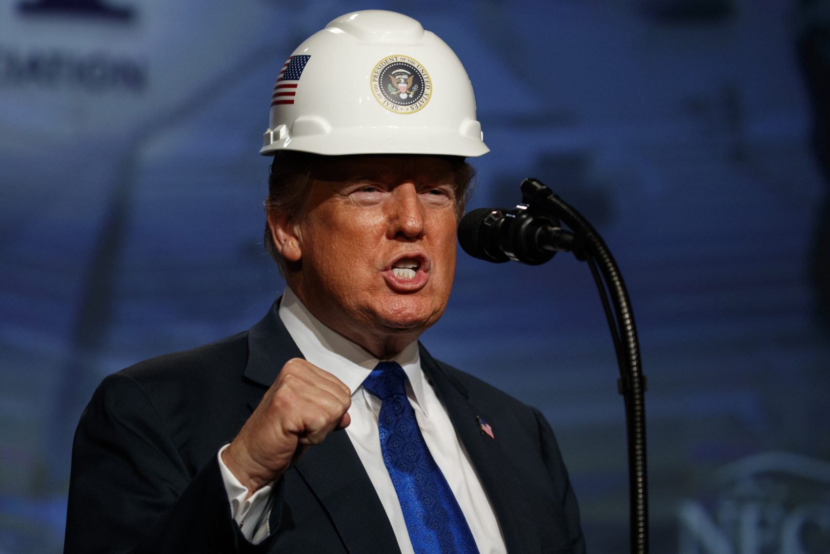 President Donald Trump pumps his fist after putting on a hard hat given to him before speaking to the National Electrical Contractors Association Convention at the Pennsylvania Convention Center, Tuesday, Oct. 2, 2018, in Philadelphia. 