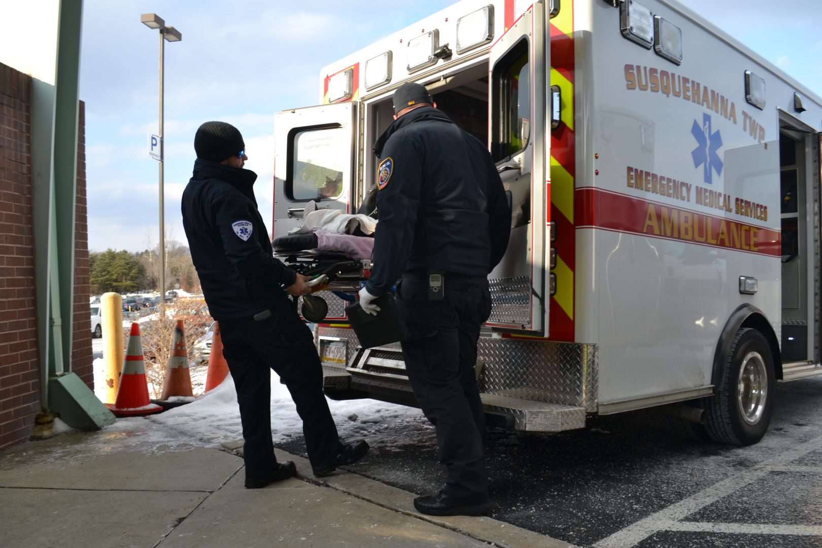 A paramedic and EMT transport someone from an ambulance to the hospital. 