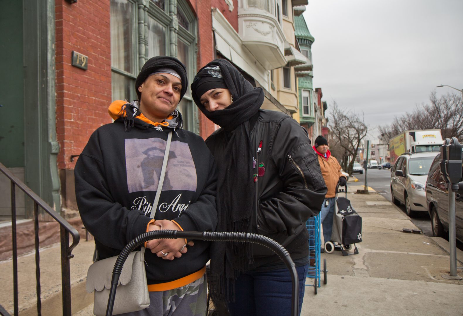 Reading residents Andrea Martinez (left) and Janelle Rasdeo are SNAP benefit recipients. They stand in line outside the St. James Chapel Church food bank Wednesday morning.