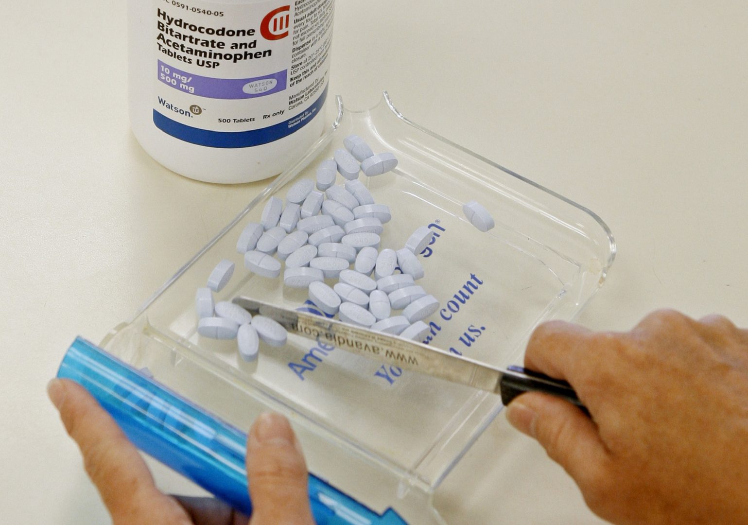 FILE PHOTO: A pharmacy tech poses for a picture with hydrocodone bitartrate and acetaminophen tablets, the generic version of Vicodin in Edmond, Okla. 