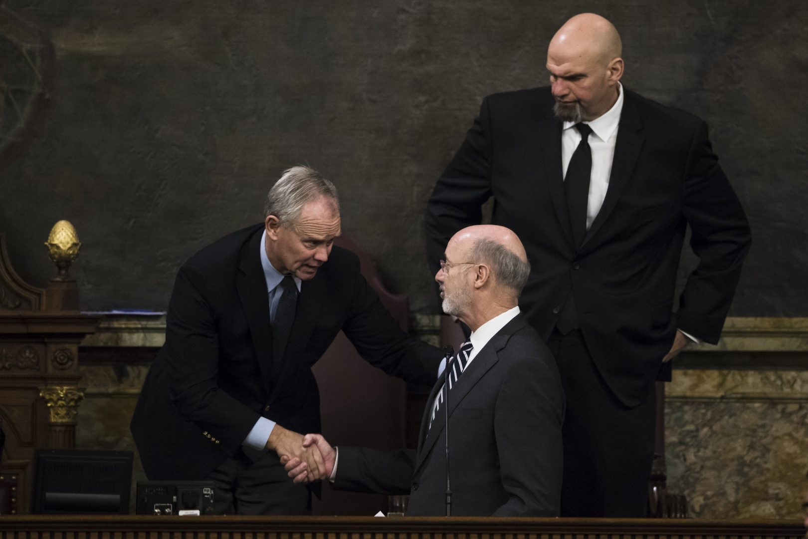 Democratic Gov. Tom Wolf, center, shakes hands with House Speaker Mike Turzai, R-Allegheny, left, as Lt. Gov. John Fetterman looks on after Wolf delivered his budget address for the 2019-20 fiscal year to a joint session of the Pennsylvania House and Senate in Harrisburg, Pa., Tuesday, Feb. 5, 2019. 