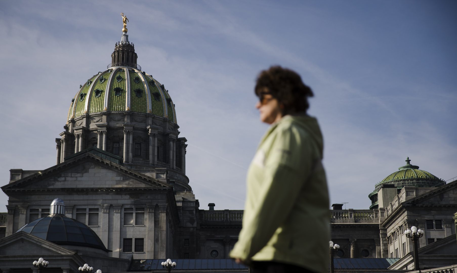 A pedestrian walks past the dome of the Pennsylvania Capitol on the morning of Democratic Gov. Tom Wolf's scheduled budget address for the 2019-20 fiscal year in Harrisburg, Pa., Tuesday, Feb. 5, 2019.