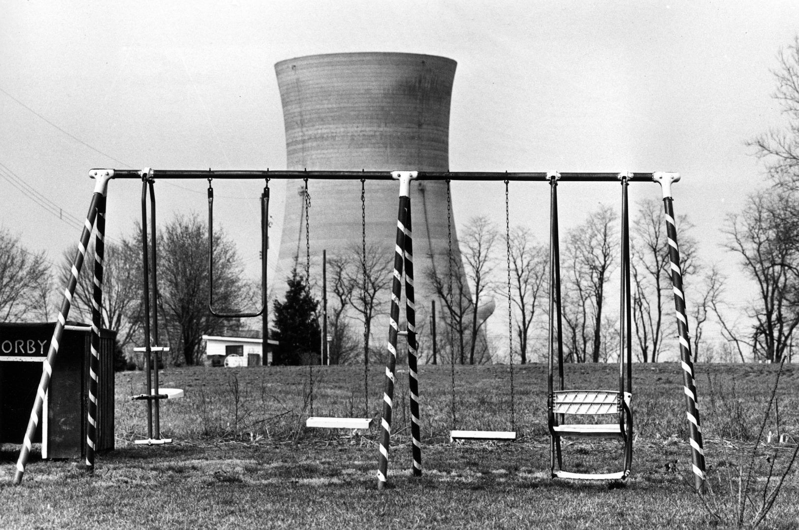 A cooling tower of the Three Mile Island nuclear power plant near Harrisburg, Pa., looms behind an abandoned playground, March 30, 1979. (Barry Thumma/AP)
