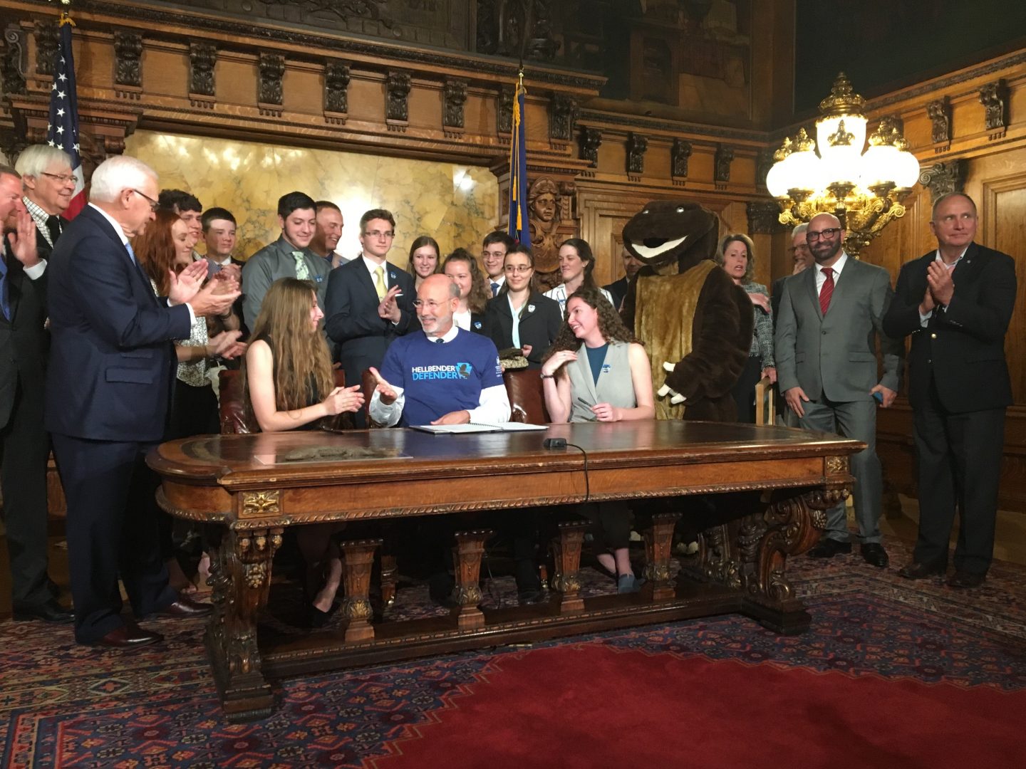 Surrounded by student hellbender-supporters -- and a mascot -- Governor Tom Wolf signs a bill officially designating the salamander state amphibian.