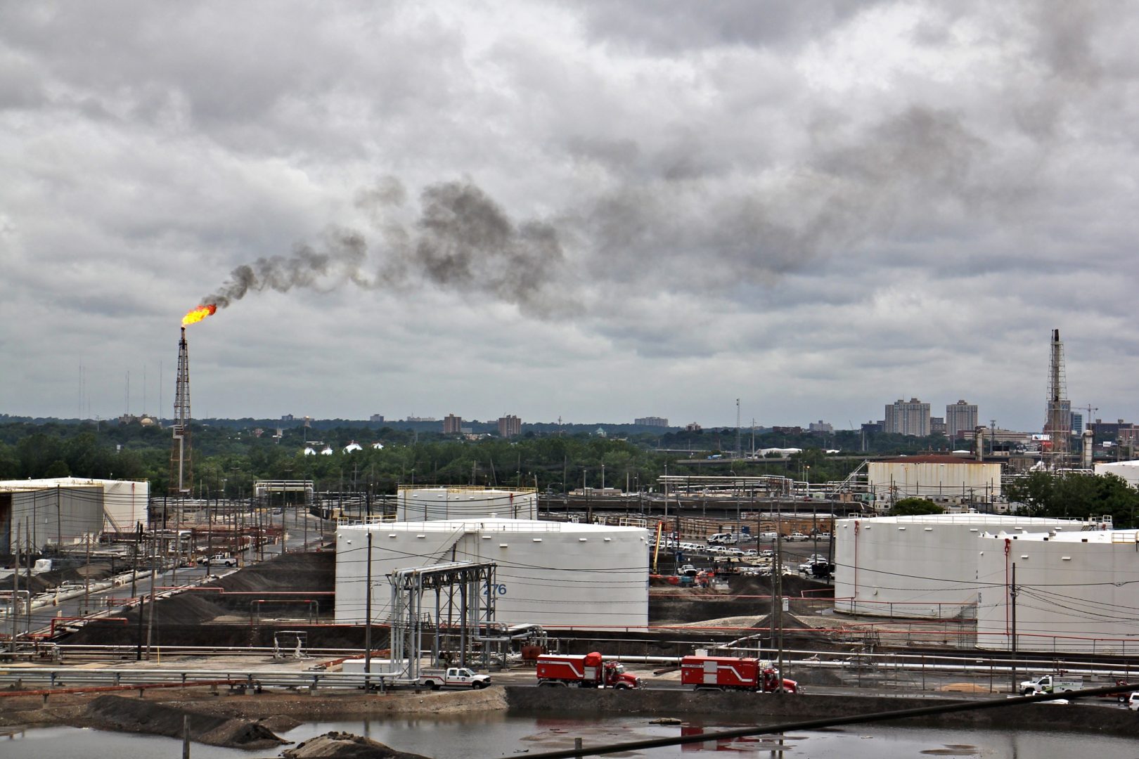 A large flare burns off fuel at Philadelphia Energy Solutions refinery while firefighters battle a fire there. The wind carried the black smoke toward residential areas of South Philadelphia. 
