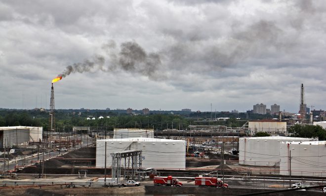 A large flare burns off fuel at Philadelphia Energy Solutions refinery while firefighters battle a fire there. The wind carried the black smoke toward residential areas of South Philadelphia. 