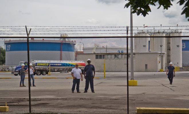 Refinery workers watch protestors outside the PES refinery Tuesday. 