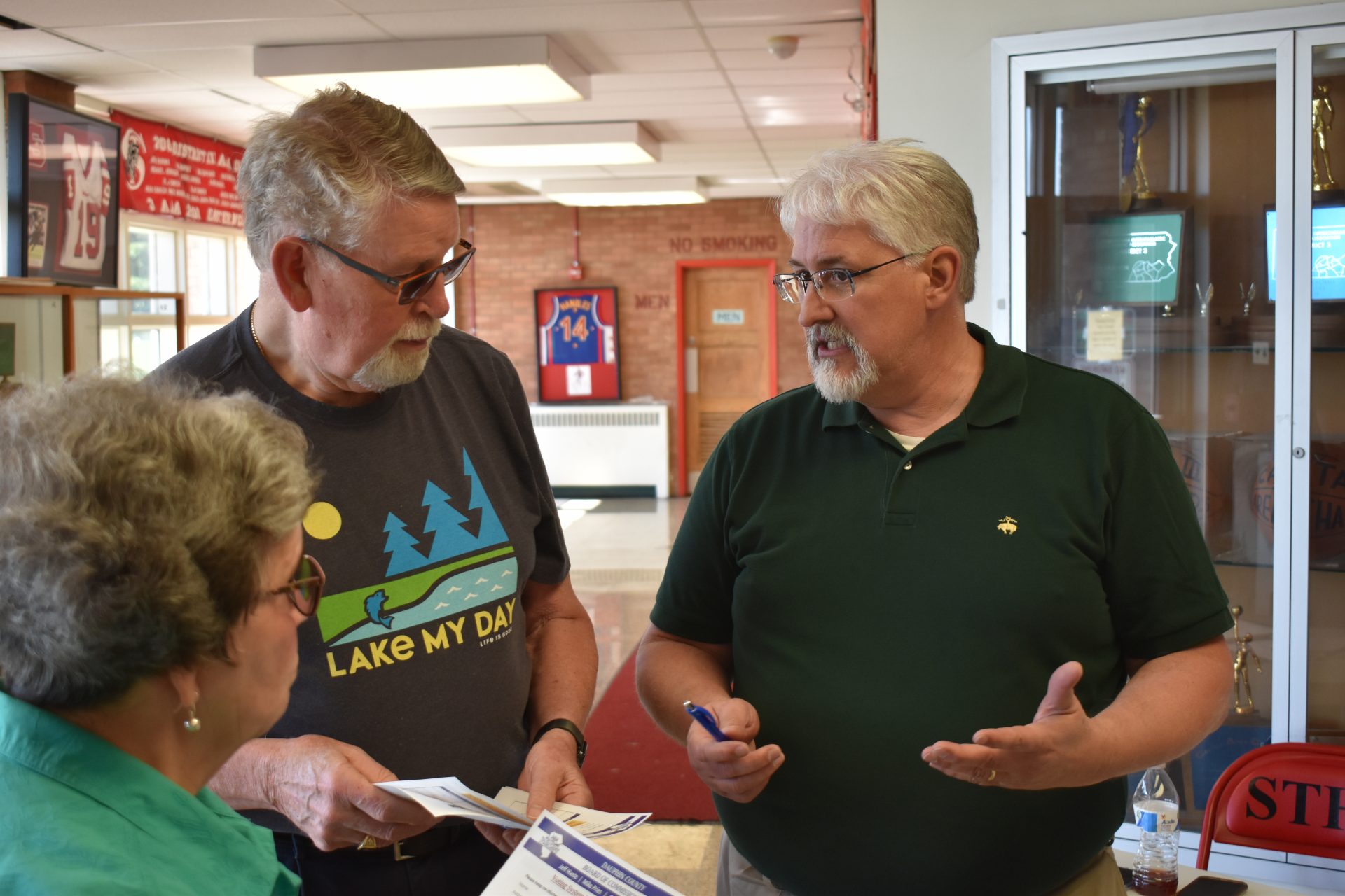 Jerry Feaser, director of elections and voter registration in Dauphin County, right, greets people at the start of voting machine demonstration on June 11, 2019, at Susquehanna Township High School.