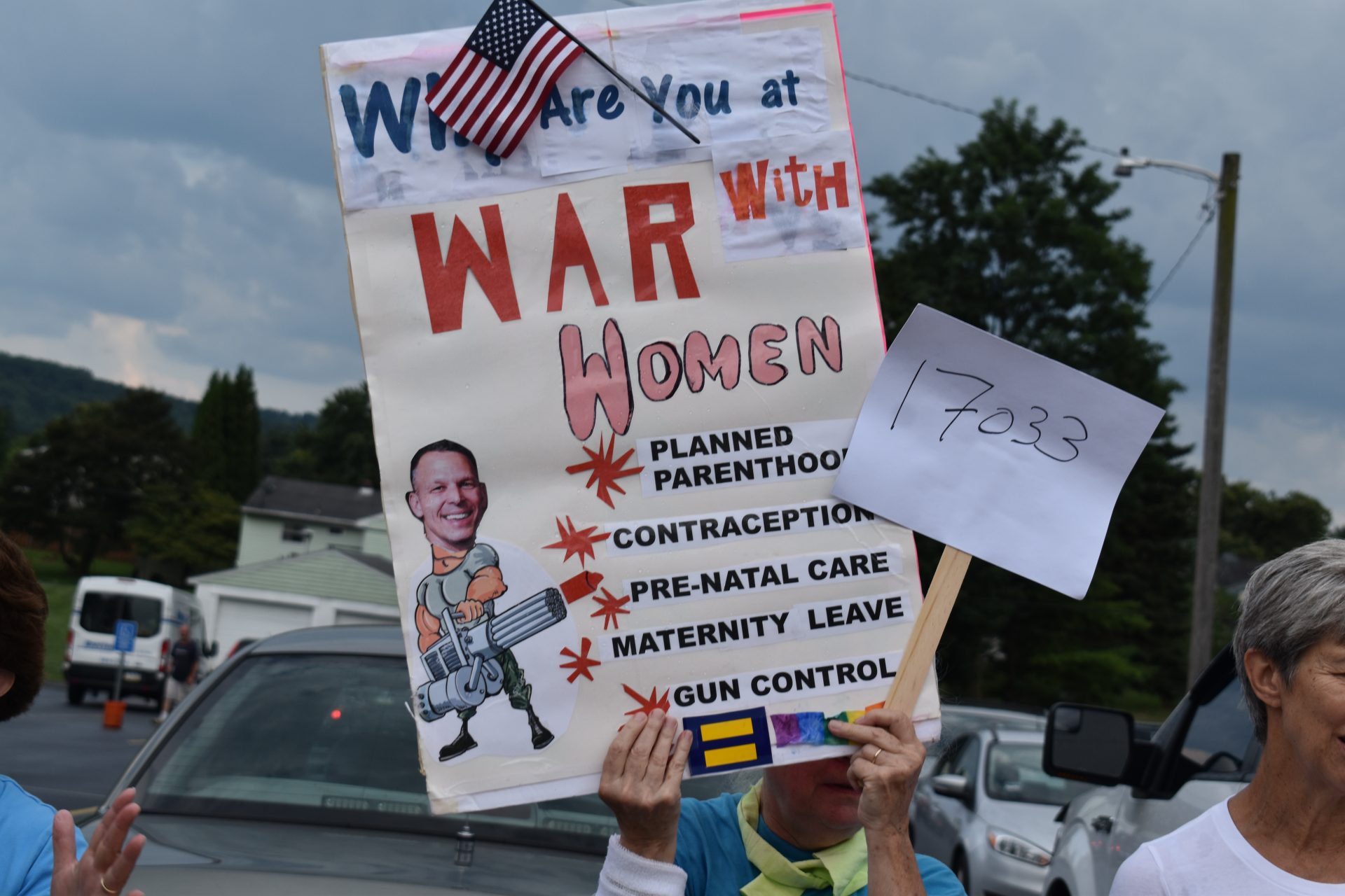 A protester holds a sign criticizing U.S. Rep. Scott Perry, R-Pa., outside the Hummelstown Fire Department on July 30, 2019.