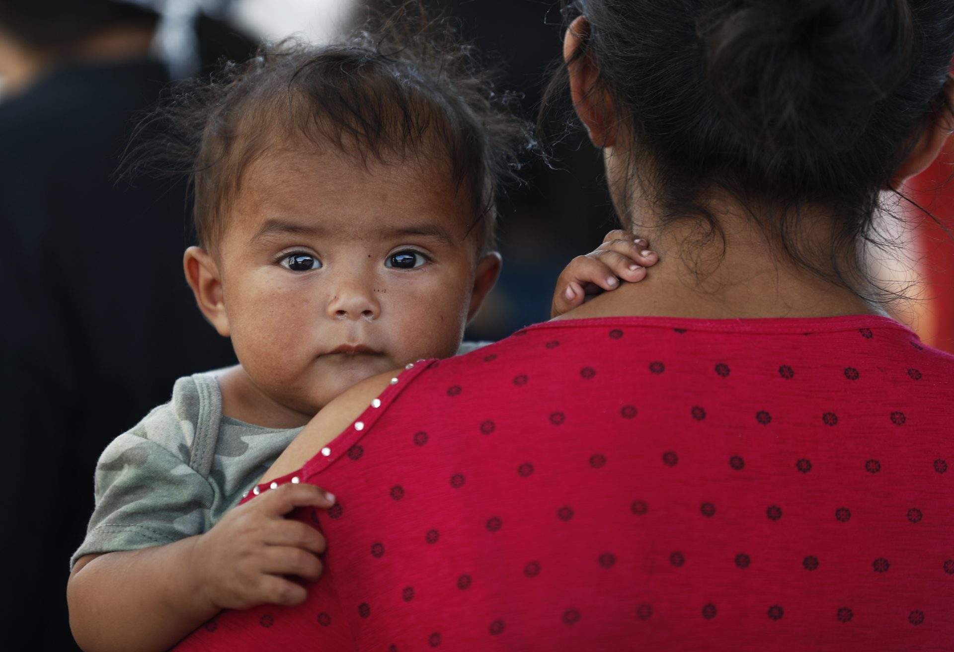 A Honduran migrant mother and her 7-month-old child stand in line to board a bus that will take them and other migrants to Monterrey, from an immigration center in Nuevo Laredo, Mexico, Thursday, July 18, 2019. 
