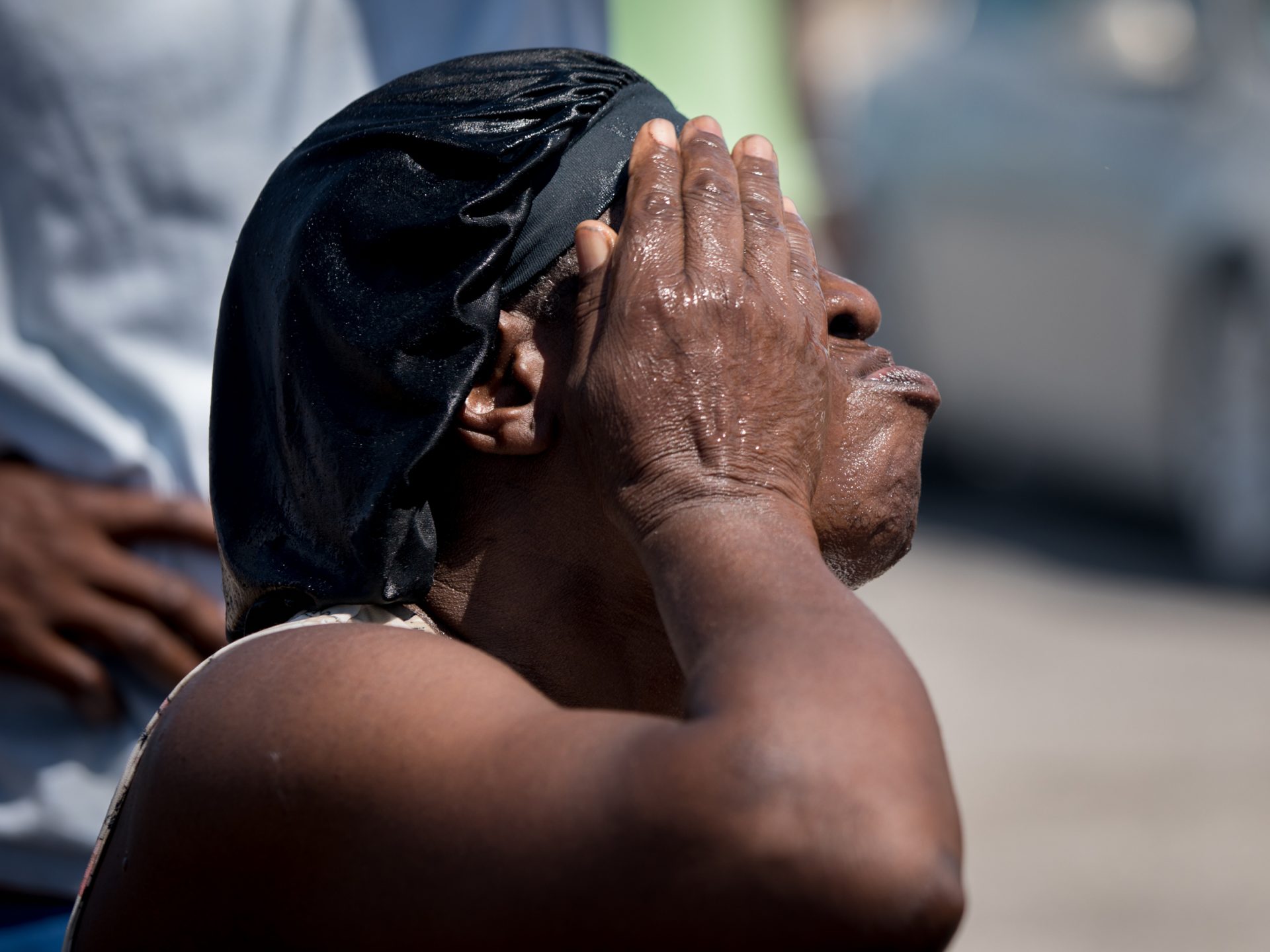 Malida Chereme, 67, tried to cool off her face while waiting in Marsh Harbour. "I'm going anywhere I find," Chereme said. "I have a visa for Miami."