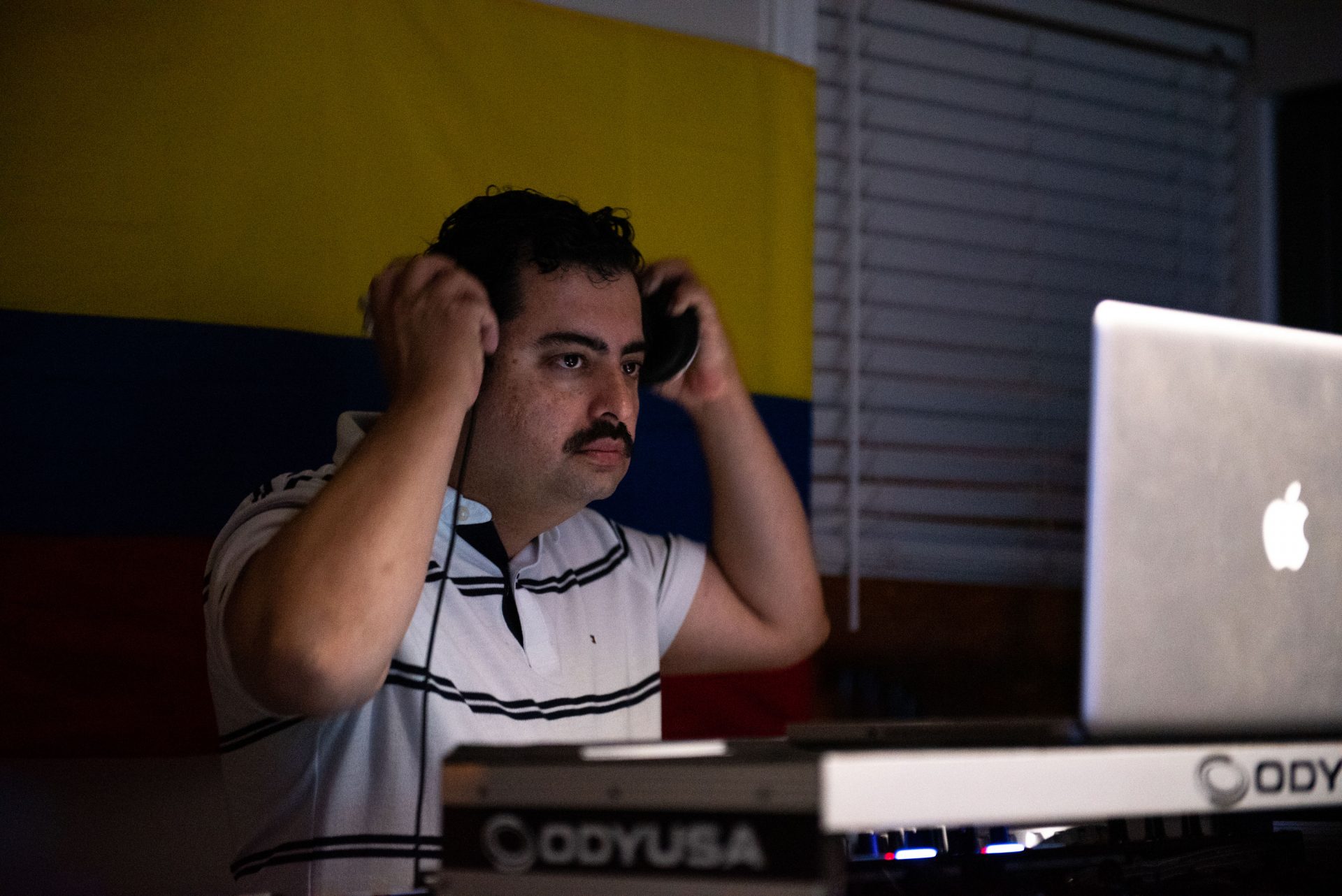 Jose Cardona, a Wilmington-area DJ, adjusts his headphones while keeping the music going during an at-home viejoteca in Oxford Circle on Saturday, September 14, 2019.