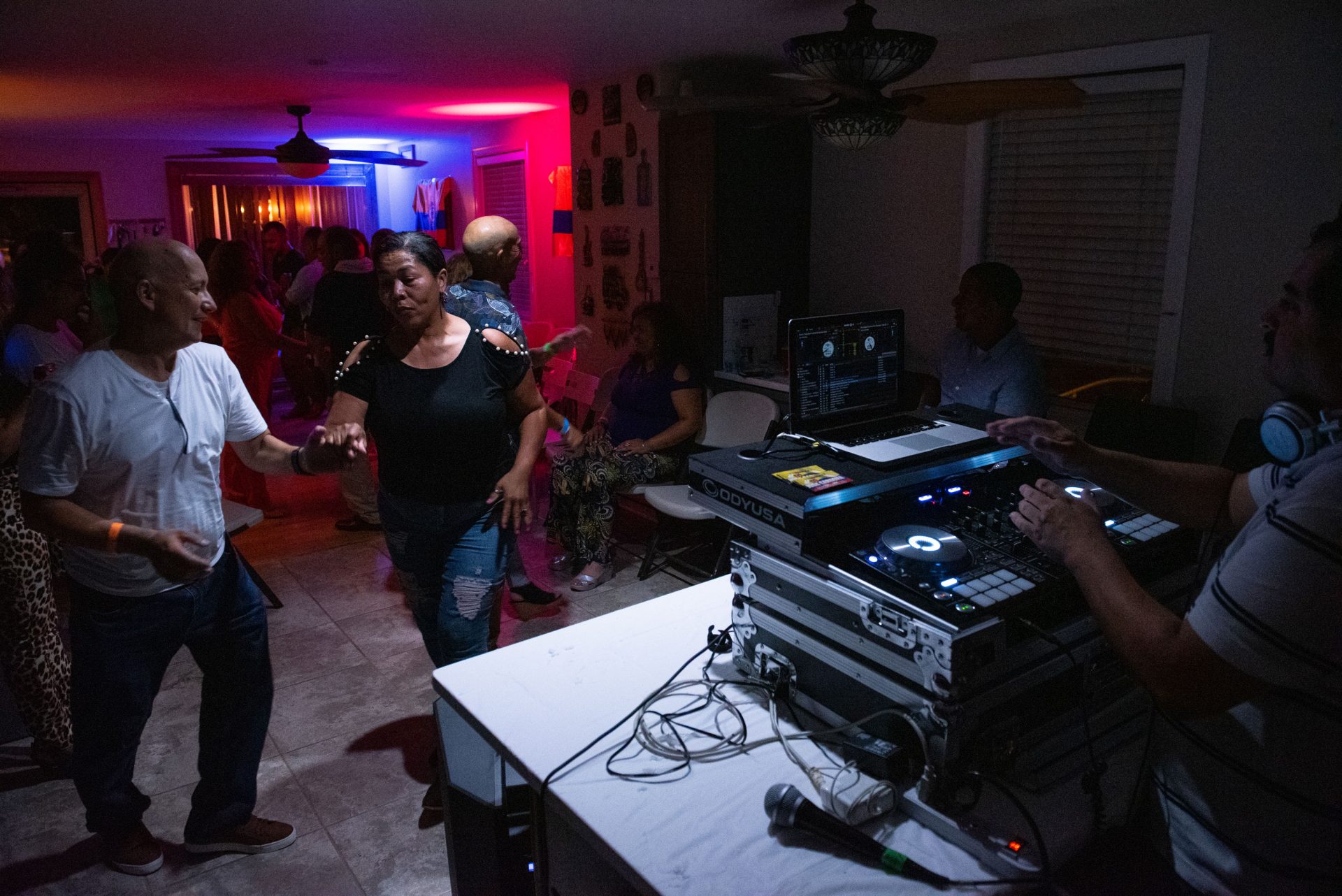 Guests dance from the kitchen to the living room at a viejoteca in Oxford Circle on Sunday, September 15, 2019.