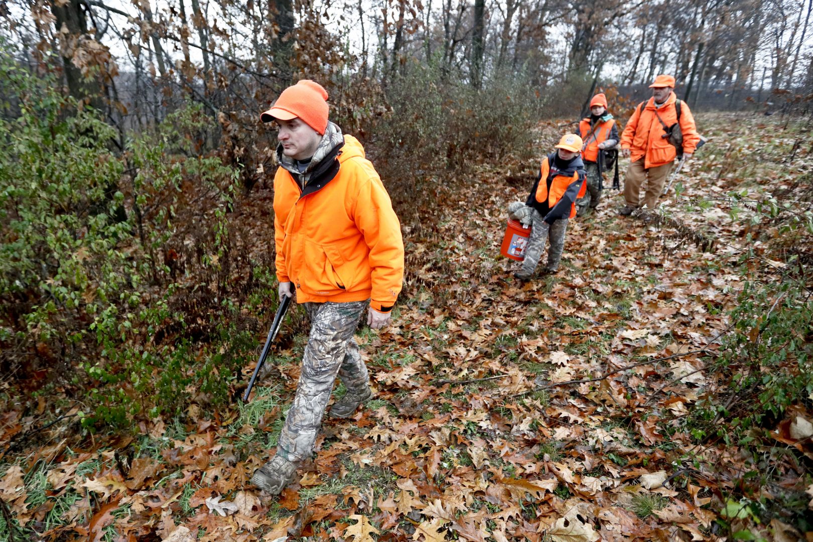 Dominick Cerminaro, left, leads his sons, Paul Cerminaro, center left, Santo Cerminaro, center right, and his father, Santo Cerminaro, right, into the woods to go deer hunting on the first day of regular firearms deer hunting season in most of Pennsylvania, Monday, Nov. 26, 2018 in Zelienople, Pa.