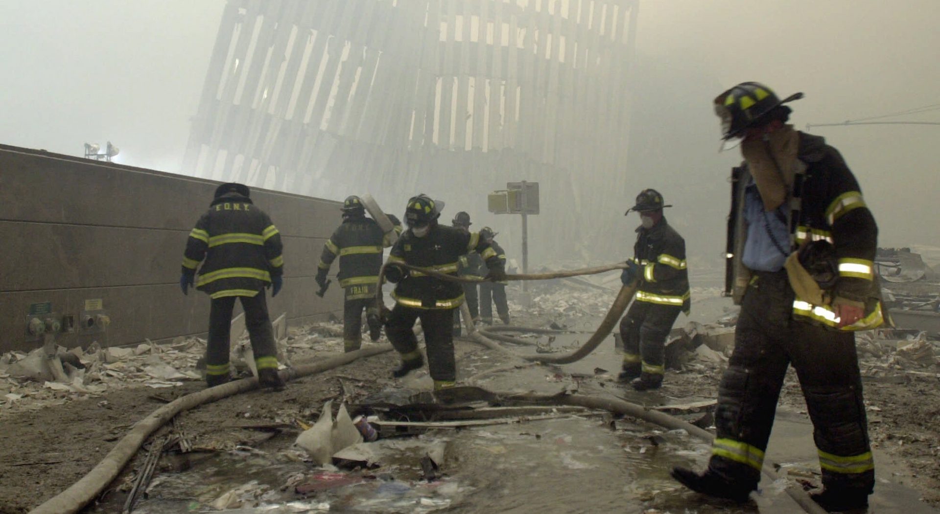 In this Sept. 11, 2001 file photo, with the skeleton of the World Trade Center twin towers in the background, New York City firefighters work amid debris on Cortlandt St. after the terrorist attacks.