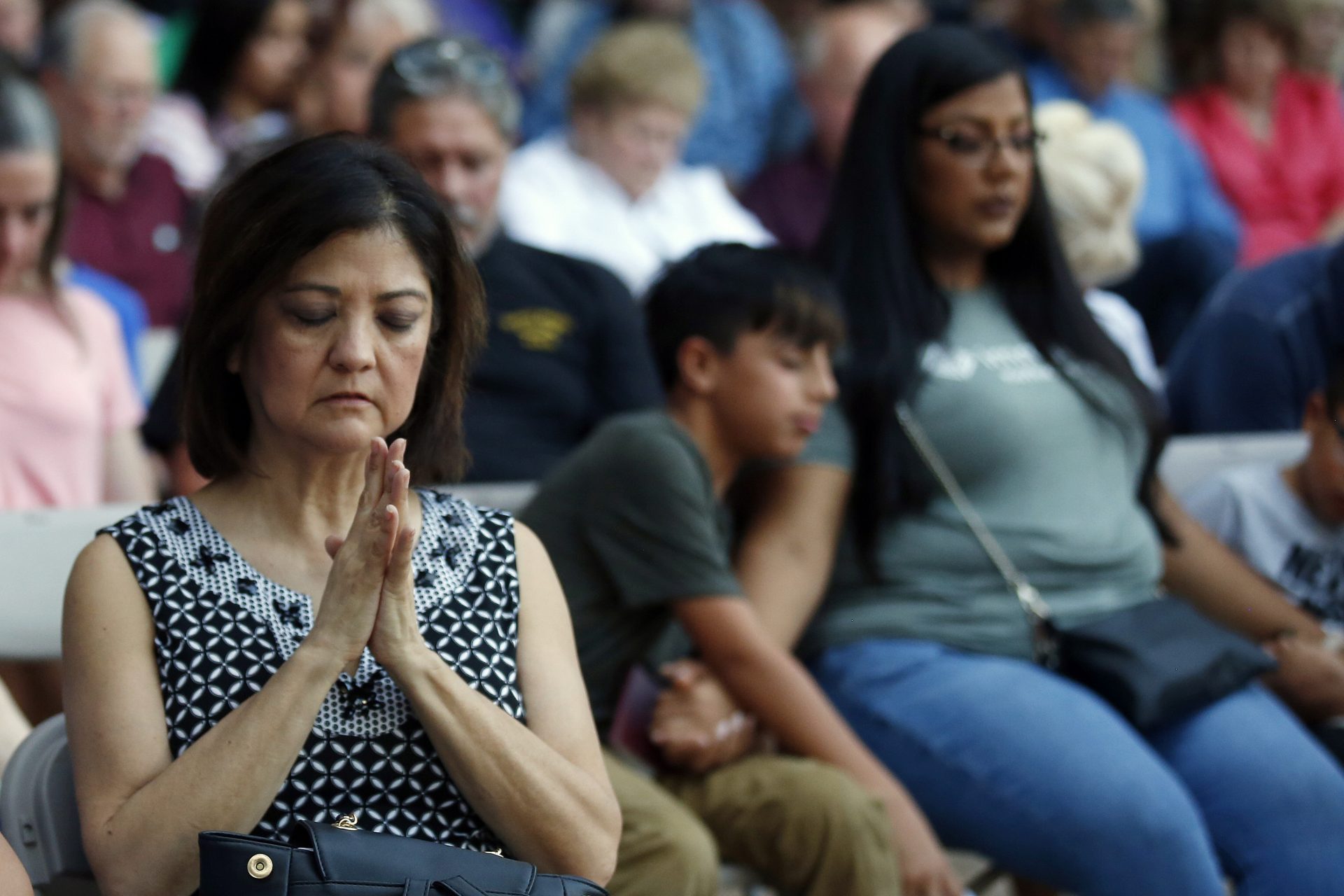 Mira Marquez, of Midland, Texas, folds her hands in prayer during a prayer service, Sunday, Sept. 1, 2019, in Odessa, Texas, for the victims of a shooting spree the day before.