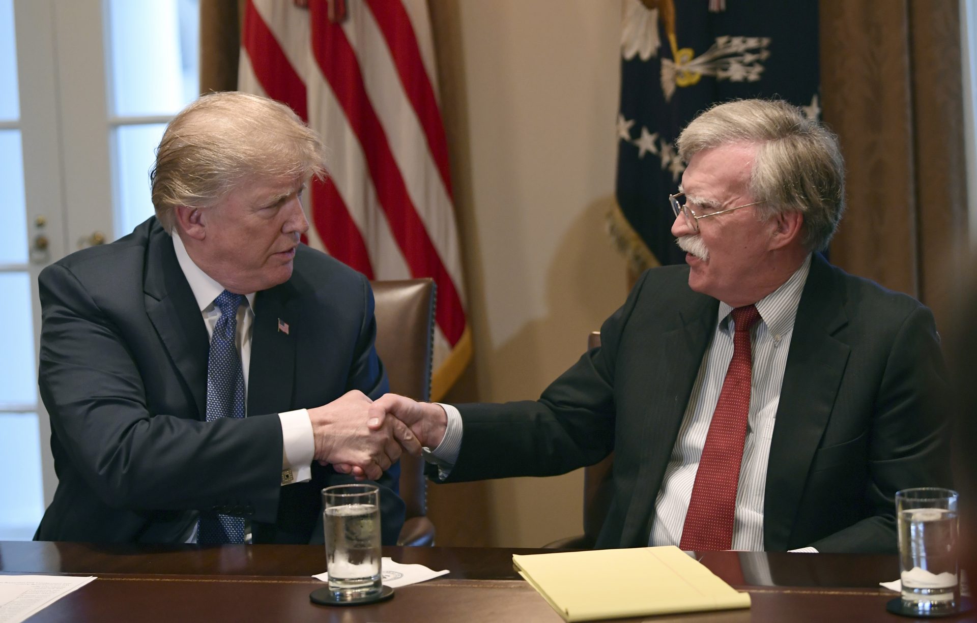 In this April 9, 2018 file photo, President Donald Trump, left, shakes hands with national security adviser John Bolton in the Cabinet Room of the White House in Washington at the start of a meeting with military leaders. Trump has fired national security adviser John Bolton.