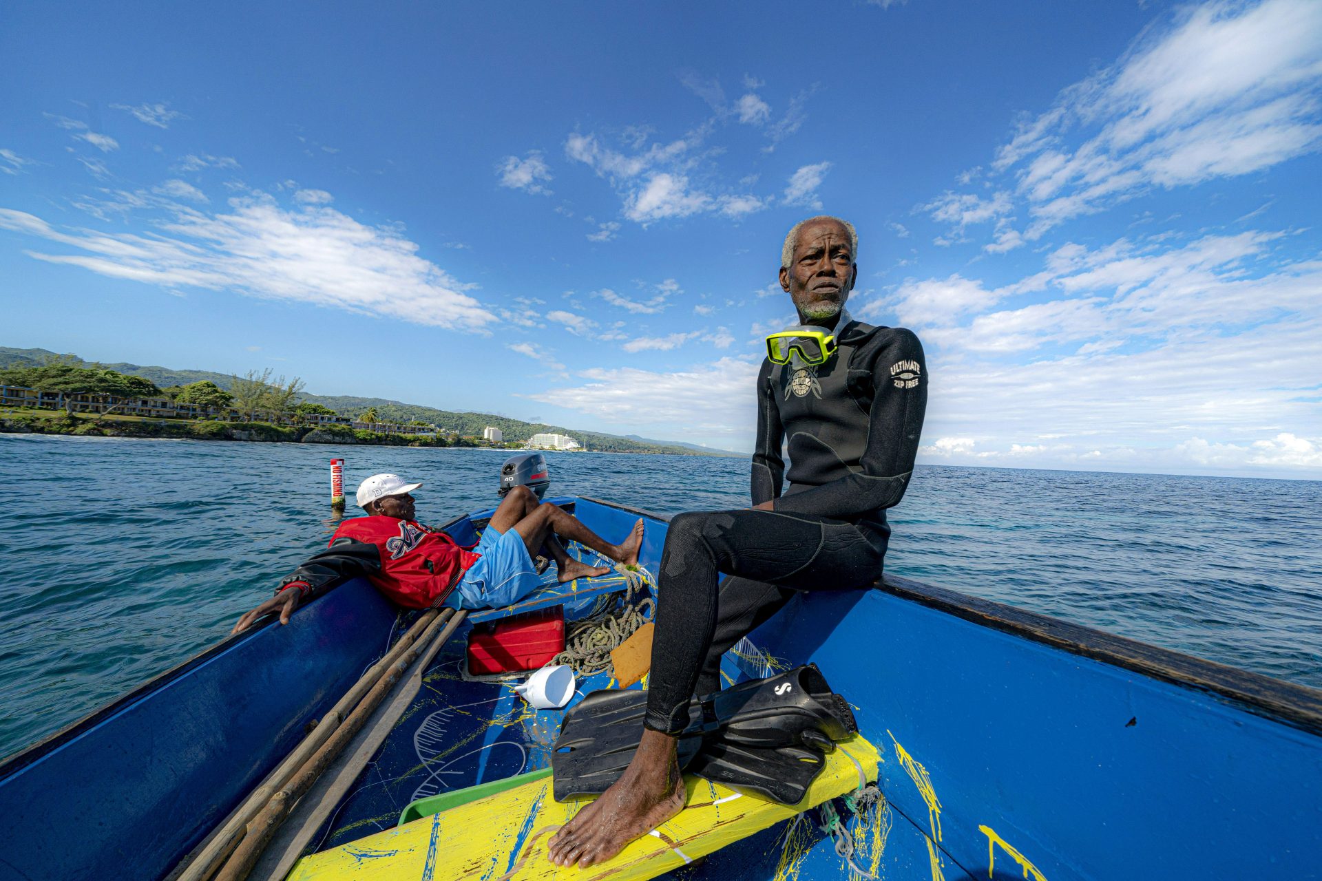 Everton Simpson, right, sits on a boat in-between dives on the White River Fish Sanctuary with Mark Lobban, left, Monday, Feb. 11, 2019, in Ocho Rios, Jamaica. More than a dozen grassroots-run fish sanctuaries and coral nurseries have sprung up on the island in the past decade.