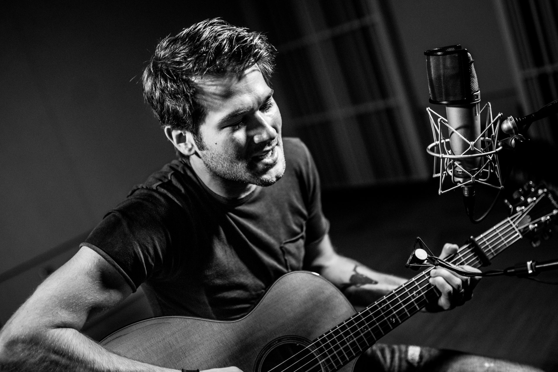 Ben Gallaher playing guitar and singing.