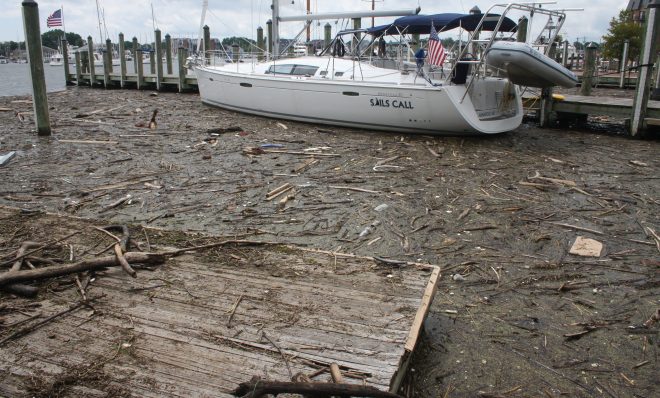 FILE - In this Aug. 1, 2018, file photo, debris washed into the Chesapeake Bay from record rainfall accumulates around a sailboat in Annapolis, Md. An annual report on the Chesapeake Bay says pollution from unusually heavy rains in 2018 contributed to the first decline in a decade in the overall health of the nation's largest estuary.