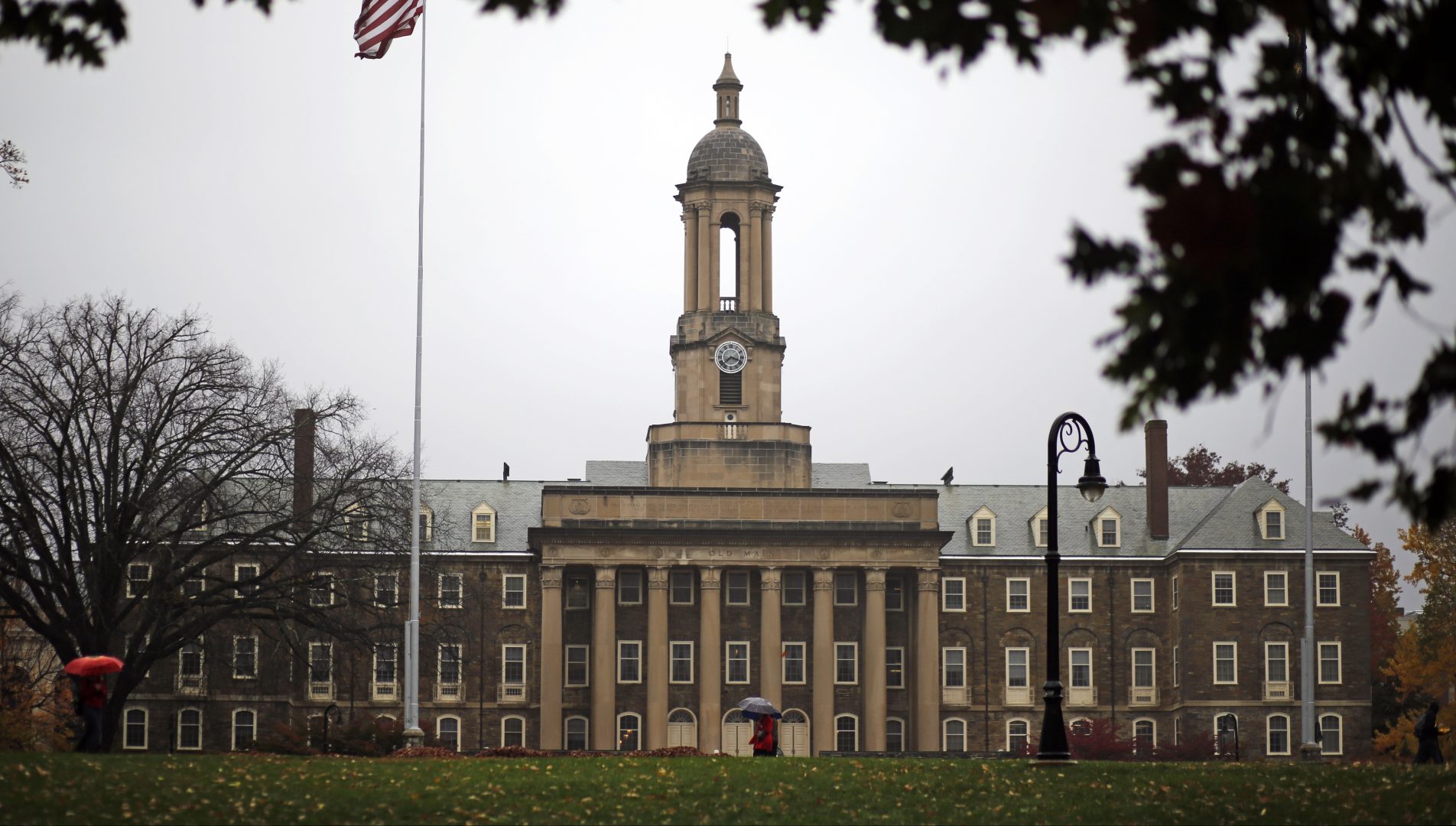 FILE PHOTO: A Penn State student walks in the rain past Old Main on the Penn State main campus in State College, Pa., Wednesday, Oct. 28, 2015. 
