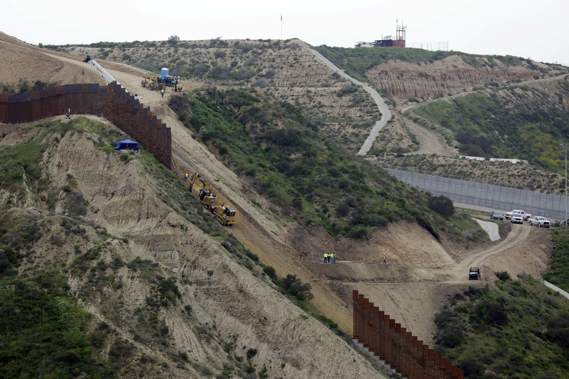 FILE PHOTO: In this March 11, 2019 photo, construction crews replace a section of the primary wall separating San Diego, above right, and Tijuana, Mexico, below left, seen from Tijuana, Mexico. Defense Secretary Mark Esper has approved the use of $3.6 billion in funding from military construction projects to build 175 miles of President Donald Trump’s wall along the Mexican border.