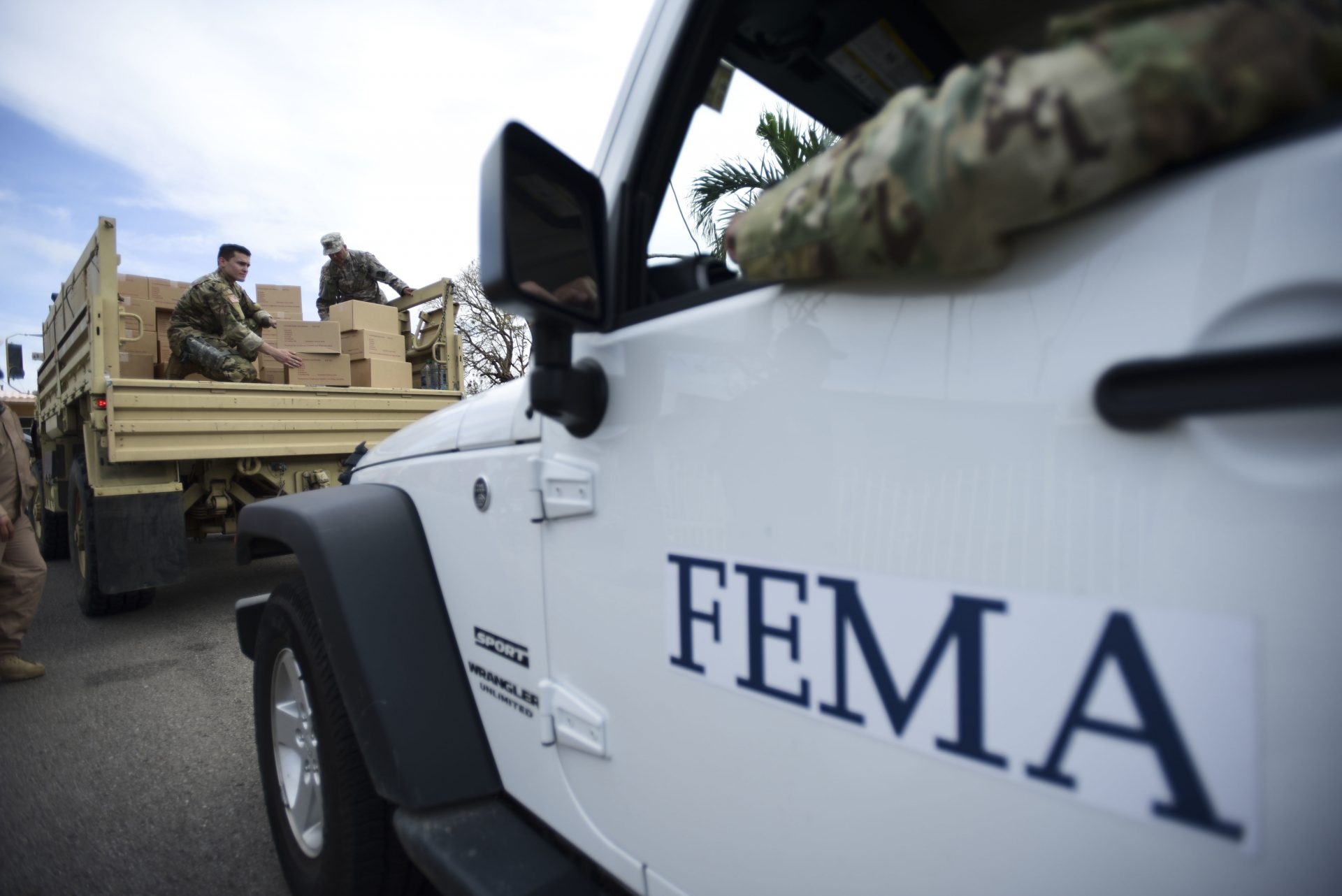 FILE PHOTO: In this Oct. 5, 2017 file photo, Department of Homeland Security personnel deliver supplies to Santa Ana community residents in the aftermath of Hurricane Maria in Guayama, Puerto Rico. Federal authorities said Tuesday, Sept. 10, 2019, that they have arrested two former officials of the Federal Emergency Management Authority and the former president of a major disaster relief contractor, accusing them of bribery and fraud in the efforts to restore electricity to Puerto Rico in the wake of Hurricane Maria.
