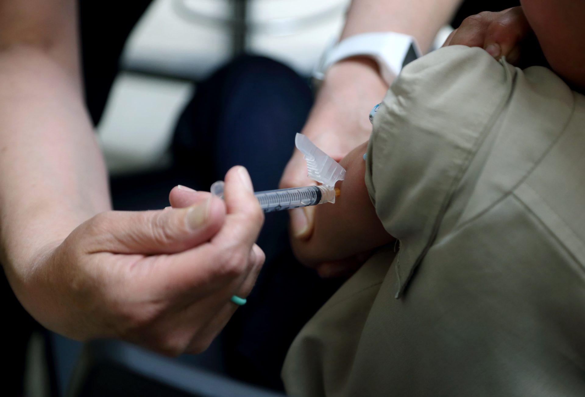 FILE PHOTO: Starr Roden, left, a registered nurse and immunization outreach coordinator with the Knox County Health Department, administers a vaccination to Jonathan Detweiler, 6, at the facility in Mount Vernon, Ohio.