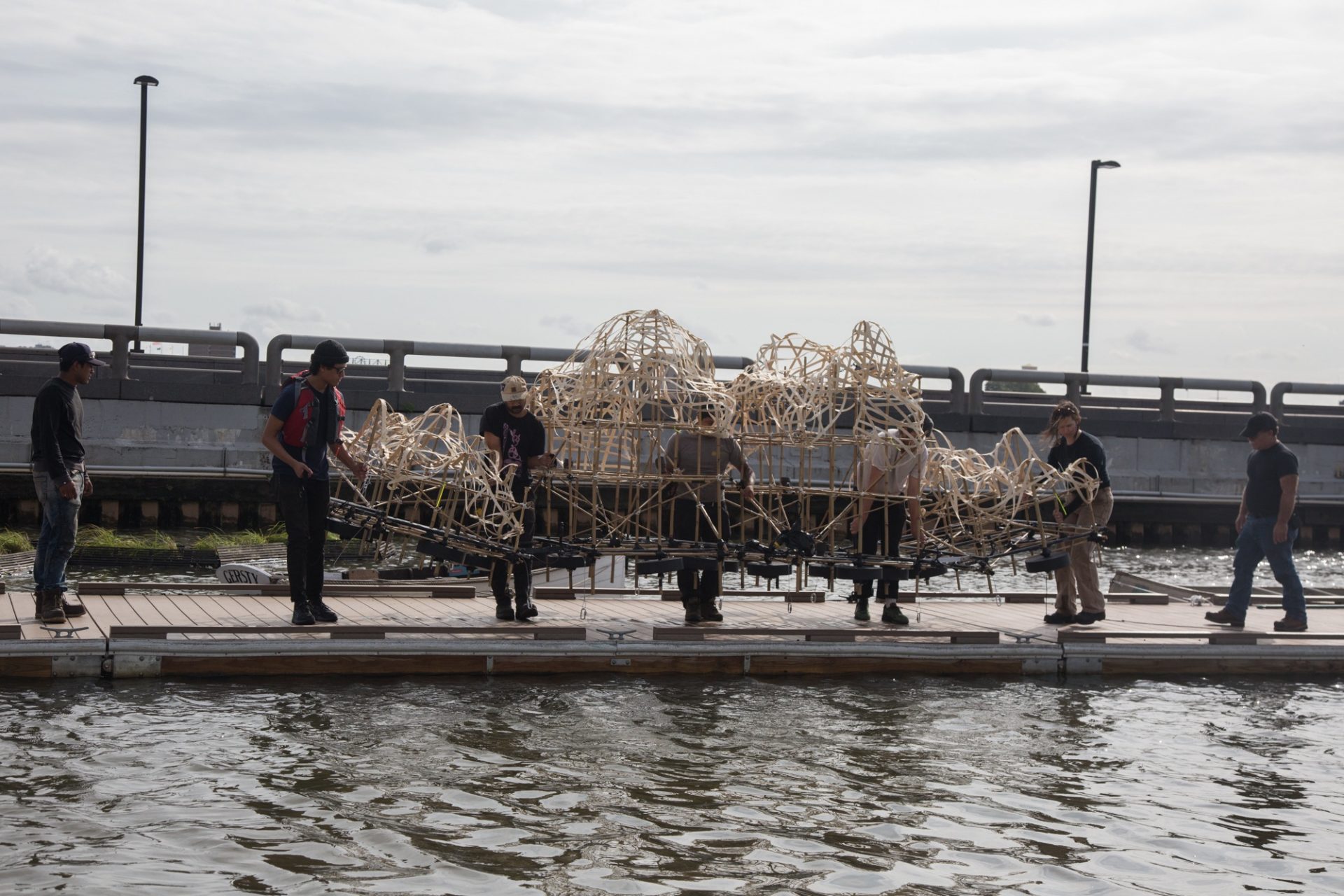 It takes four workers to lift and slowly introduce Talasnik's sculpture into the Delaware River boat basin.