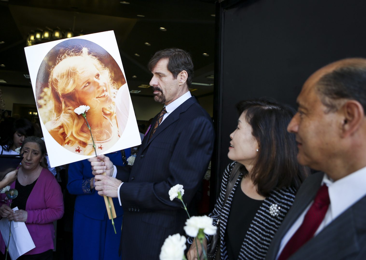 Dr. Henry T. Nicholas III holds a photo of his sister Marsy, who was killed in 1983 by an ex-boyfriend, during the Orange County Victims' Rights March and Rally, Friday, April 26, 2013, in Santa Ana, Calif. 