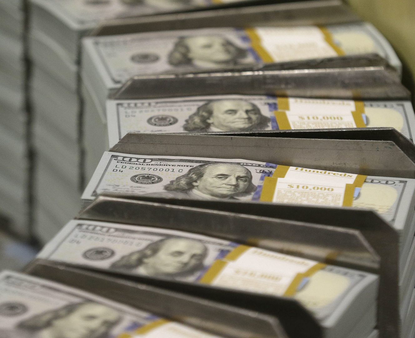 In this Sept. 24, 2013 file photo, cut stacks of $100 bills make their way down the line at the Bureau of Engraving and Printing Western Currency Facility in Fort Worth, Texas. According to a study released on Tuesday, April 3, 2018, middle-aged Americans who experienced a sudden, large economic blow were more likely to die during the following years than those who didn’t. The heightened danger of death after a devastating loss, which researchers called a “wealth shock,” crossed socio-economic lines, affecting people no matter how much money they had to start.