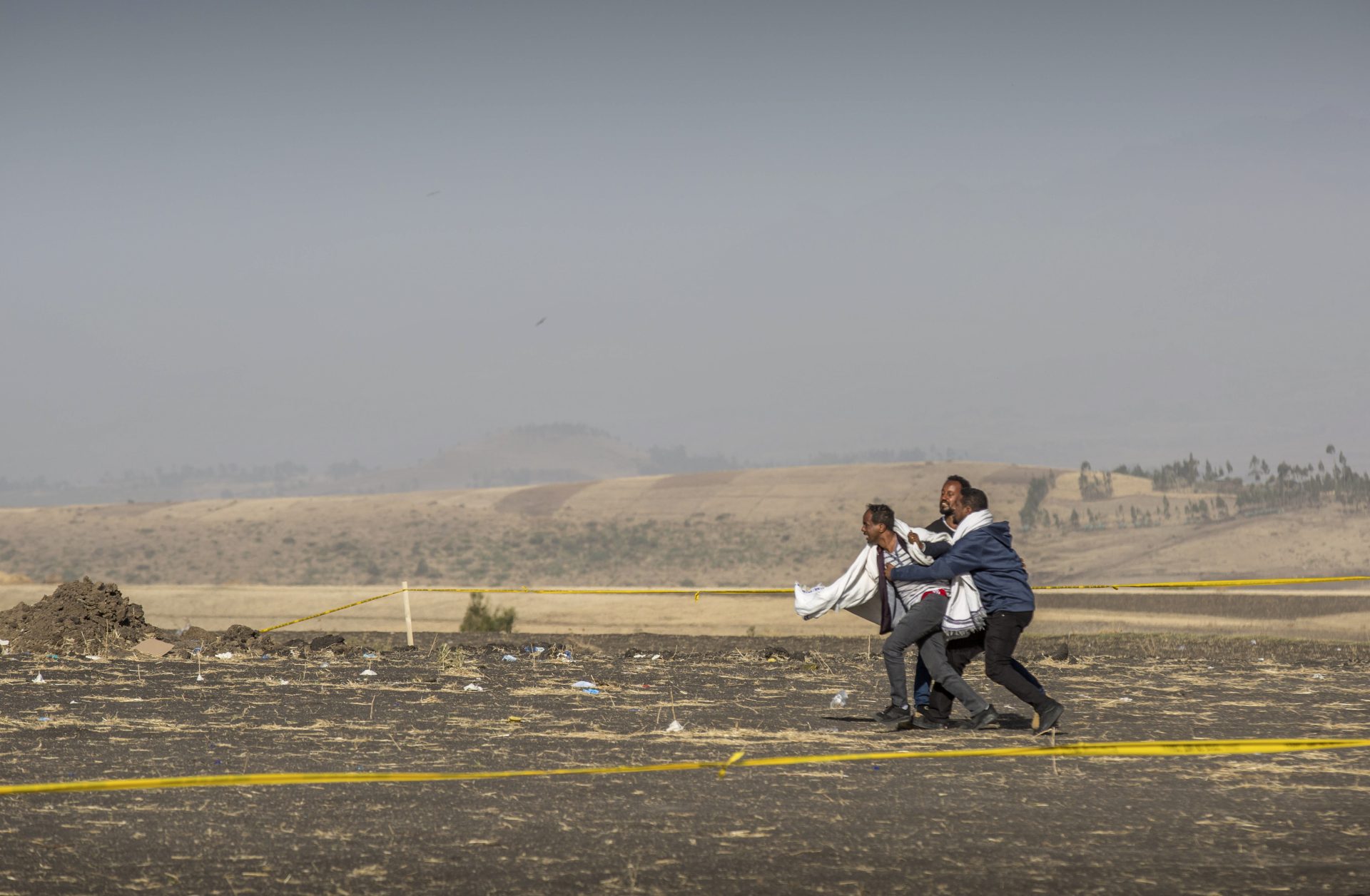 FILE PHOTO: A grieving relative is held back by others at the scene where the Ethiopian Airlines Boeing 737 Max 8 crashed shortly after takeoff, killing all 157 on board, near Bishoftu, or Debre Zeit, south of Addis Ababa, in Ethiopia Wednesday, March 13, 2019. 