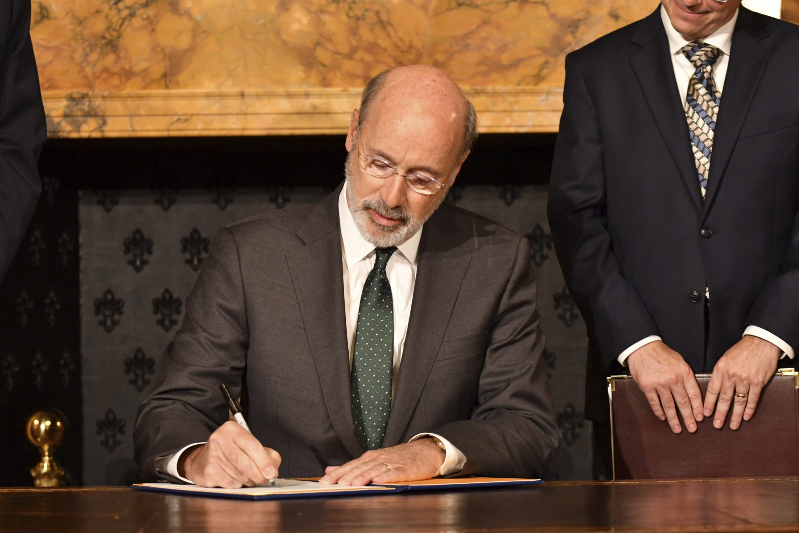 Pennsylvania Gov. Tom Wolf signs an executive order for his administration to start working on regulations to bring Pennsylvania into a nine-state consortium that sets a price and limits on greenhouse gas emissions from power plants, Thursday, Oct. 3, 2019 in Harrisburg, Pa. The move is part of Wolf's effort to fight climate change in the nation's fourth-biggest emitter of greenhouse gases. 