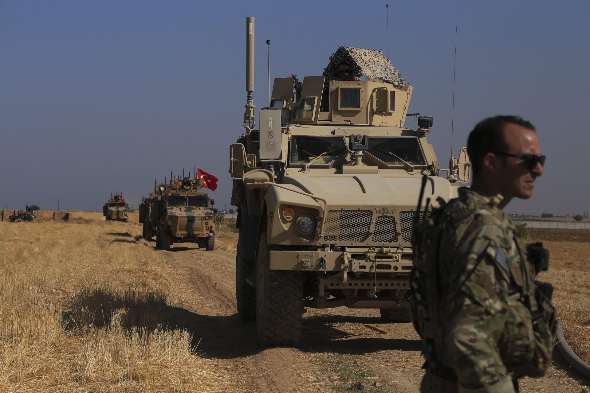 This Friday, Oct. 4, 2019 file photo, Turkish and American armored vehicles patrol as they conduct joint ground patrol in the so-called "safe zone" on the Syrian side of the border with Turkey, near the town of Tal Abyad, northeastern Syria.