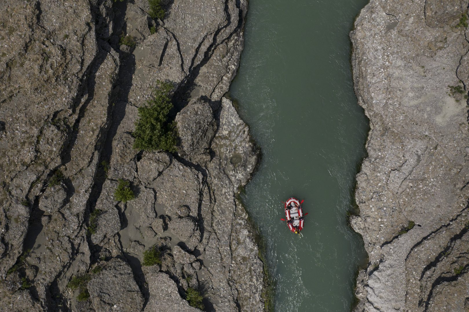 In this June 25, 2019 photo, people raft on the Vjosa River near Permet, Albania. Some tout hydropower as a reliable, cheap and renewable energy source that helps curb dependence on planet-warming fossil fuels like coal, oil and natural gas. But some critics like EcoAlbania say the benefits of hydropower are overstated _ and outweighed by the harm dams can do.