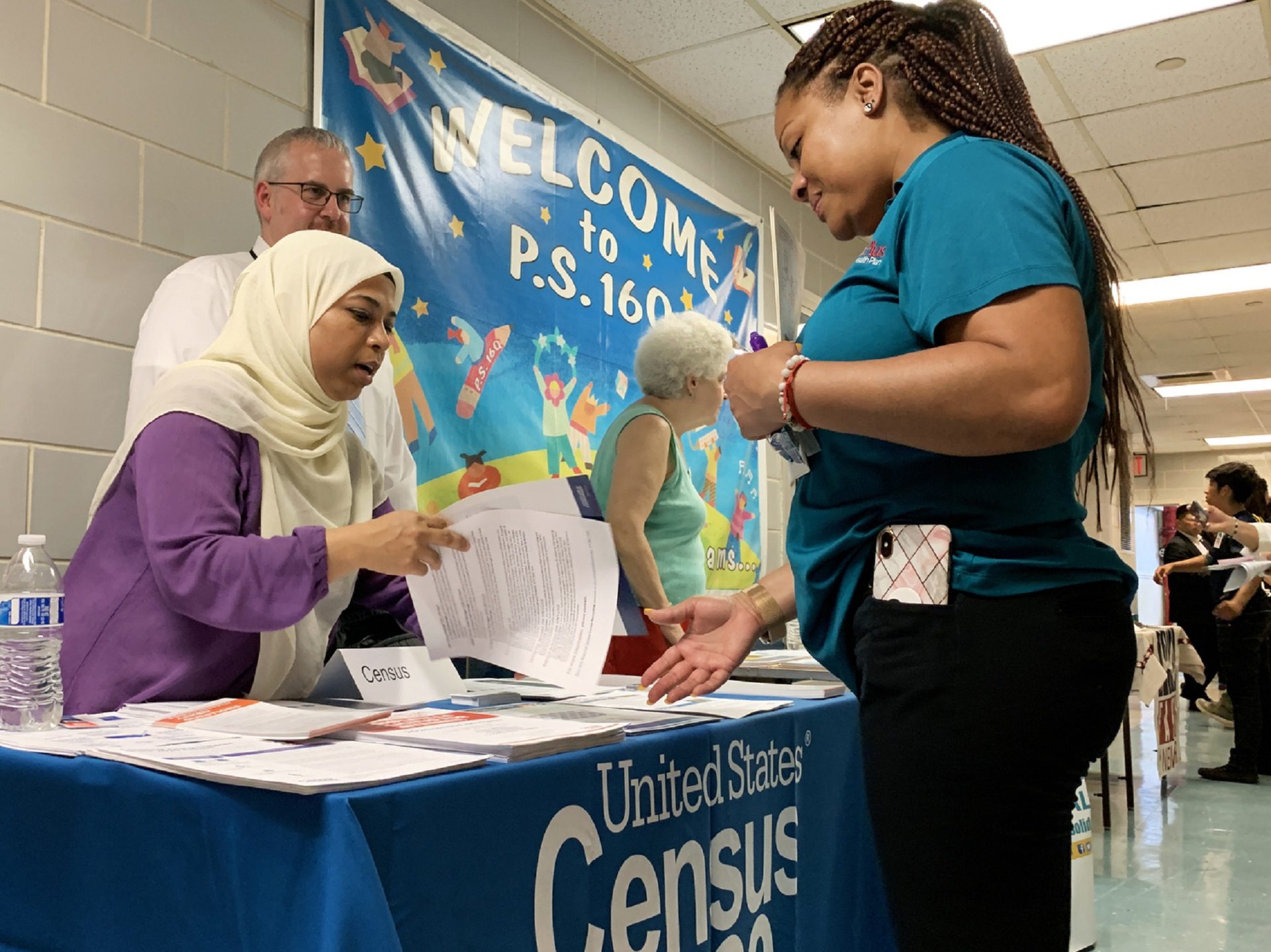 Census Bureau partnership specialist Zakera Ahmed (left) and Jeff Behler, a regional director with the bureau, share information about the 2020 census at an elementary school in Corona, N.Y., in July.