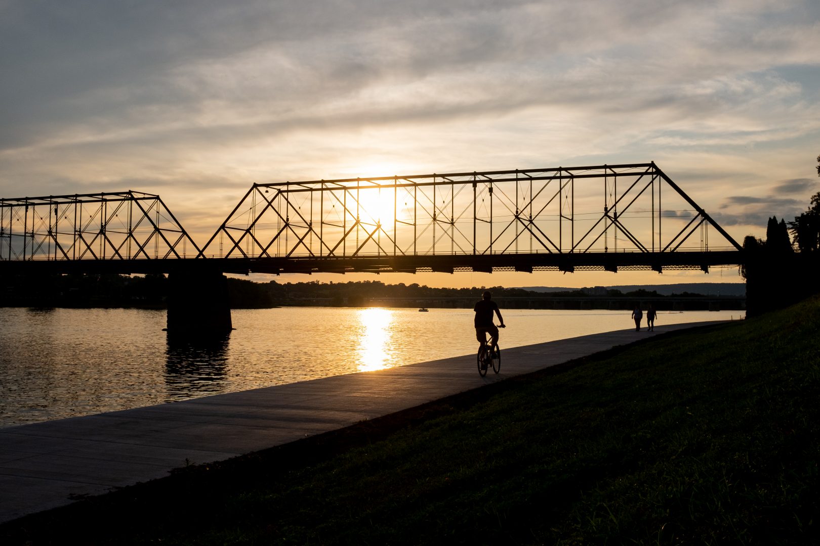 A bicyclist and pedestrians travel next to the Susquehanna River in Harrisburg on Aug. 19, 2019. 