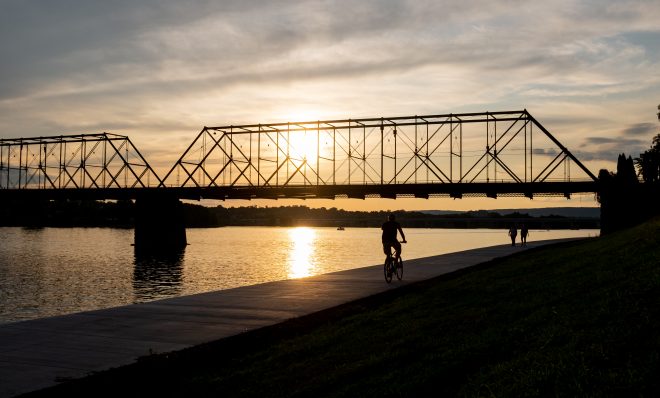 A bicyclist and pedestrians travel next to the Susquehanna River in Harrisburg on Aug. 19, 2019. 