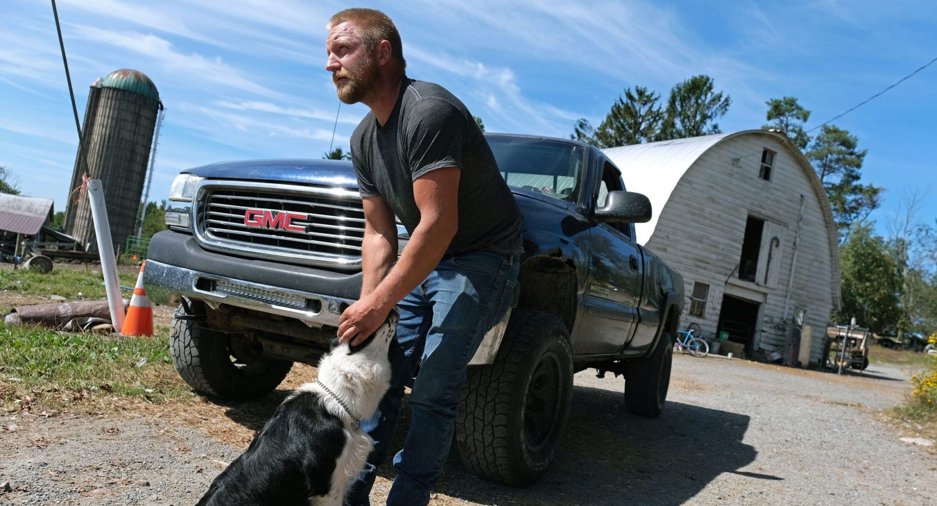 Grain farmer Jesse Poliskiewicz pets a dog while visiting his father's farm Sept. 20, 2019, in Upper Mount Bethel Township, Pennsylvania. 