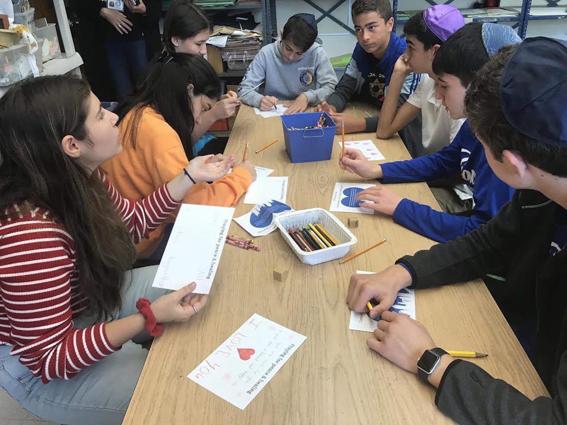 Eighth graders write postcards Friday morning at the Community Day School.