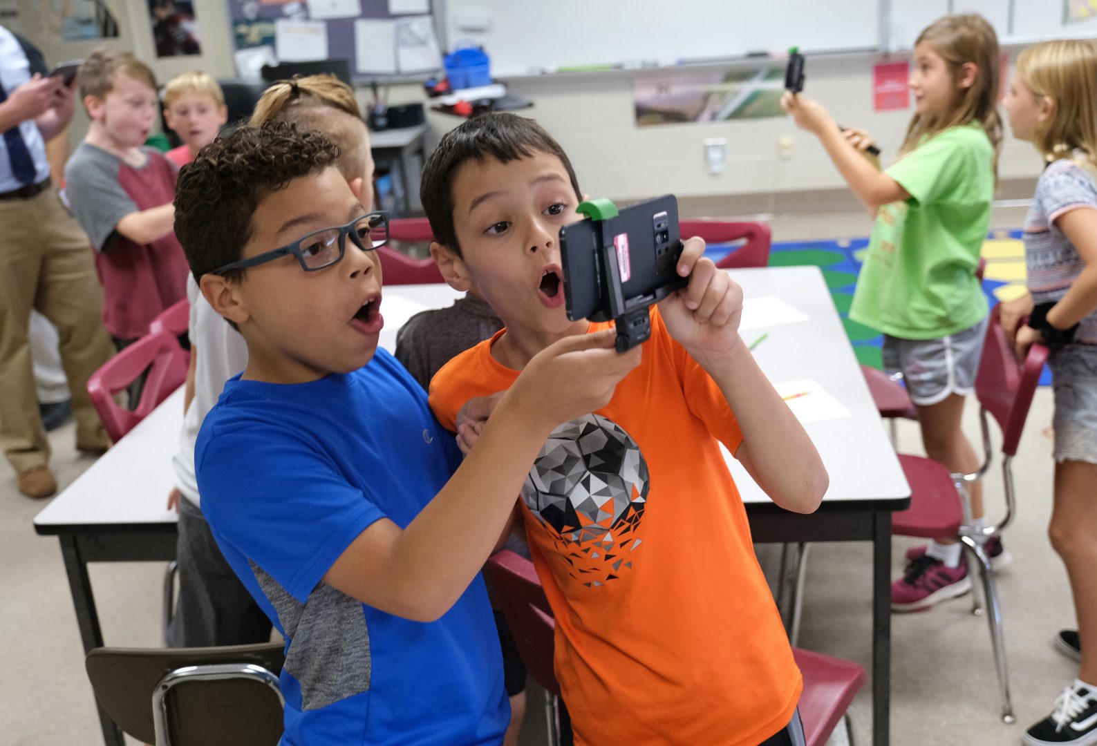 Dante Guzman, left, 8, and Emre Tokuc, right, 8, work with a tornado simulation augmented reality program on a smartphone Sept. 26, 2019, at Whitfield Elementary School in Spring Township, Pennsylvania. 
