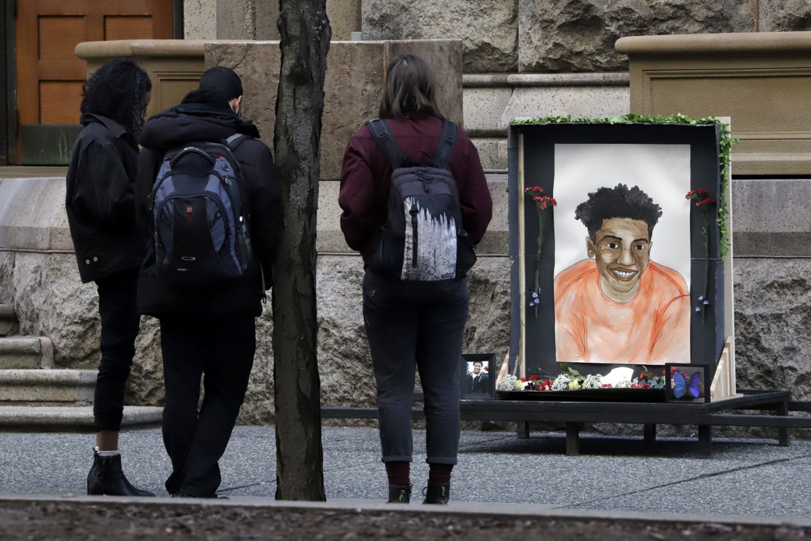People gather in front of a memorial display with a drawing of Antwon Rose II in front of the Allegheny County courthouse on the second day of the trial for Michael Rosfeld, a former police officer in East Pittsburgh, Pa., Wednesday, March 20, 2019.