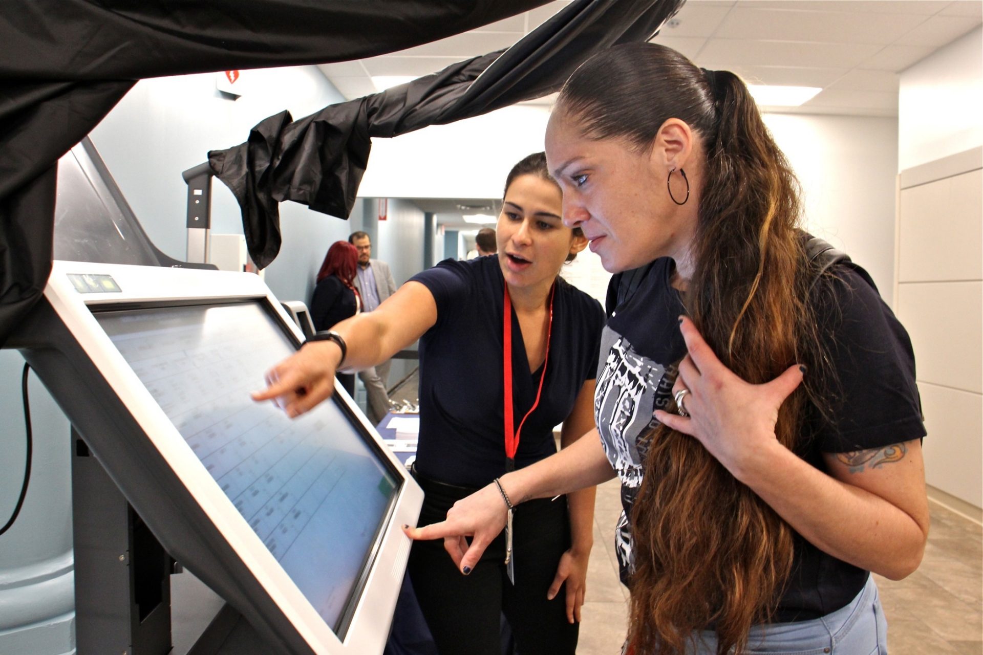 Diane Duffin learns how to use a voting machine with the help of Michelle Montalvo of the City Commissioners Office. Duffin registered to vote for the first time after learning that a conviction did not prevent her from voting in Pennsylvania.