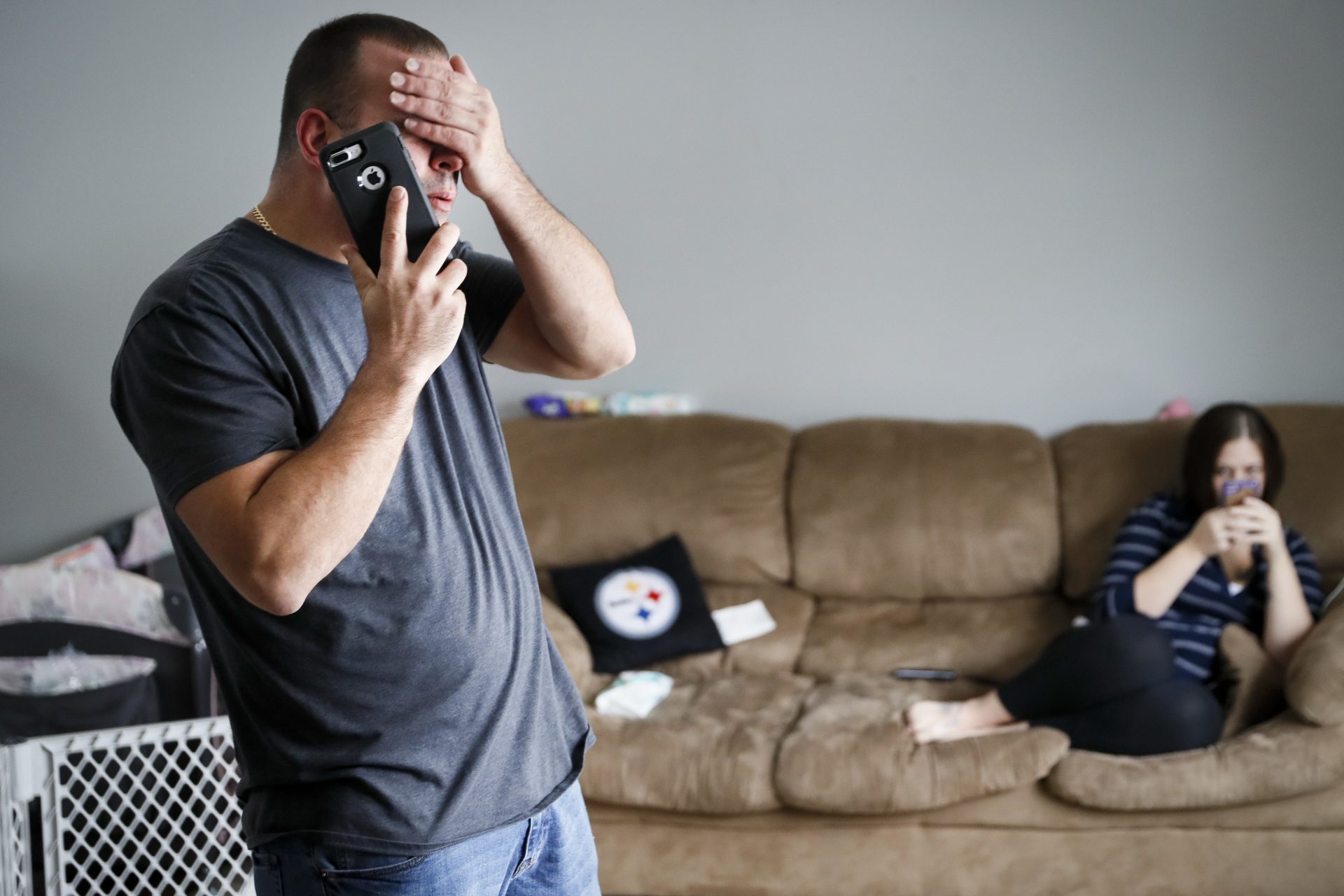 FILE PHOTO: In this Nov. 28, 2018, file photo Tom Wolikow, a General Motors employee who is currently laid-off, left, takes a phone call at home alongside his fiance Rochelle Carlisle in Warren, Ohio. An economic renaissance in the industrial Midwest promised by President Donald Trump has suffered in recent weeks in ways that could be problematic for Trump's 2020 re-election.