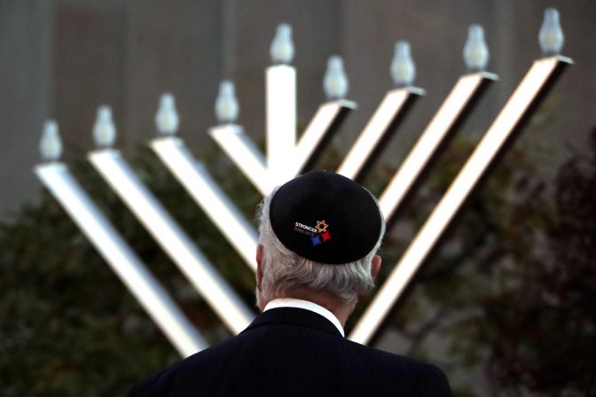 Rabbi Jeffrey Myers watches the installation of a menorah outside the Tree of Life Synagogue before holding a celebration on the first night of Hanukkah, Sunday, Dec. 2, 2018, in the Squirrel Hill neighborhood of Pittsburgh. A gunman shot and killed 11 people while they worshipped Saturday, Oct. 27, at the temple.