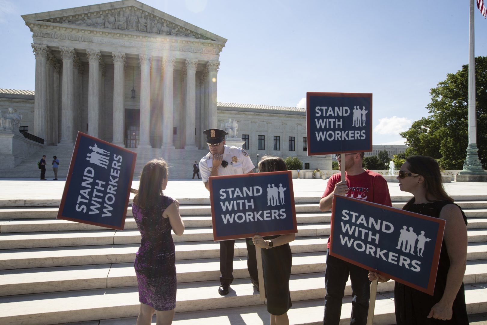 People gather at the Supreme Court awaiting a decision in an Illinois union dues case, Janus vs. AFSCME, in Washington, Monday, June 25, 2018. The outcome of that case and several others were not announced Monday as the court's term comes to a close. (AP Photo/J. Scott Applewhite)