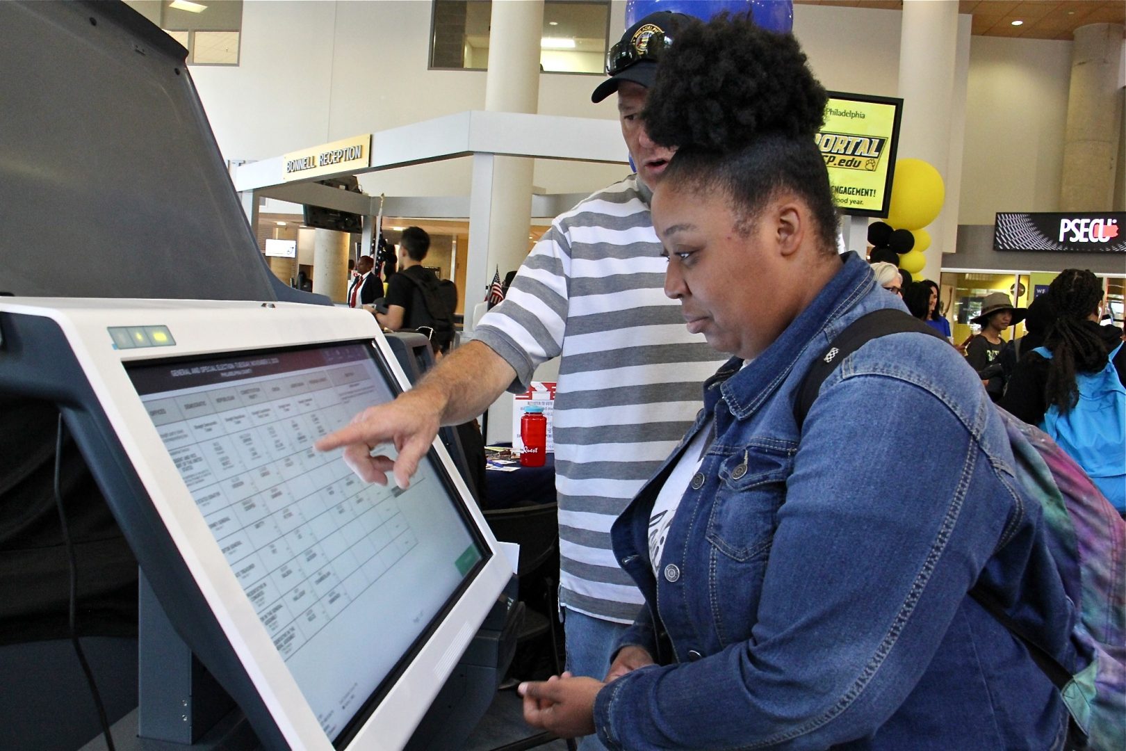 Community College of Philadelphia student Hanna Archibald, 20, learns how to use a new voting machine from Matthew McKeon of the City Commissioners Office.
