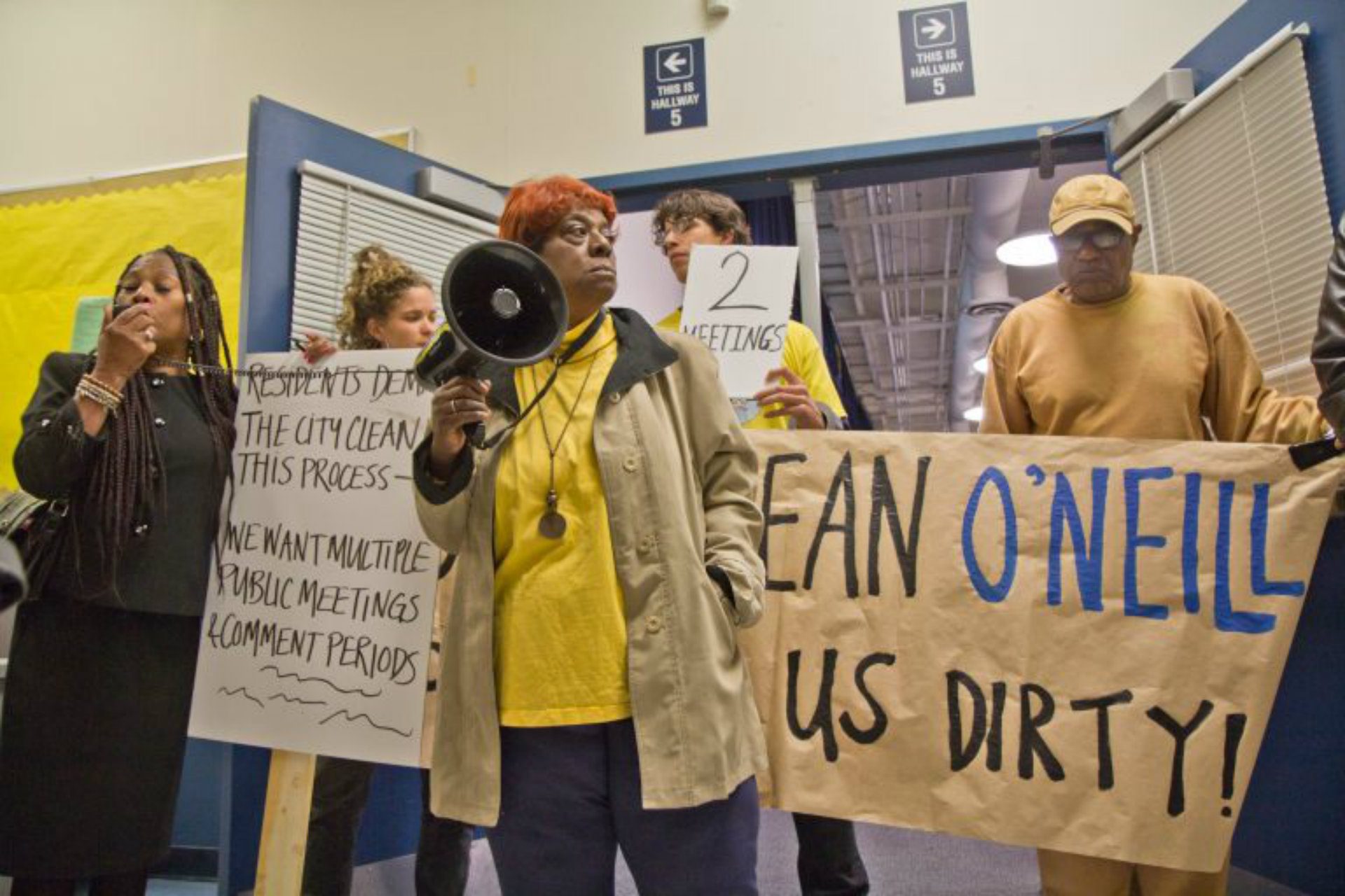 South Philly resident Carol White and other members of Philly Thrive block the entrance to a public meeting about the refinery Thursday evening. (Kimberly Paynter/WHYY)