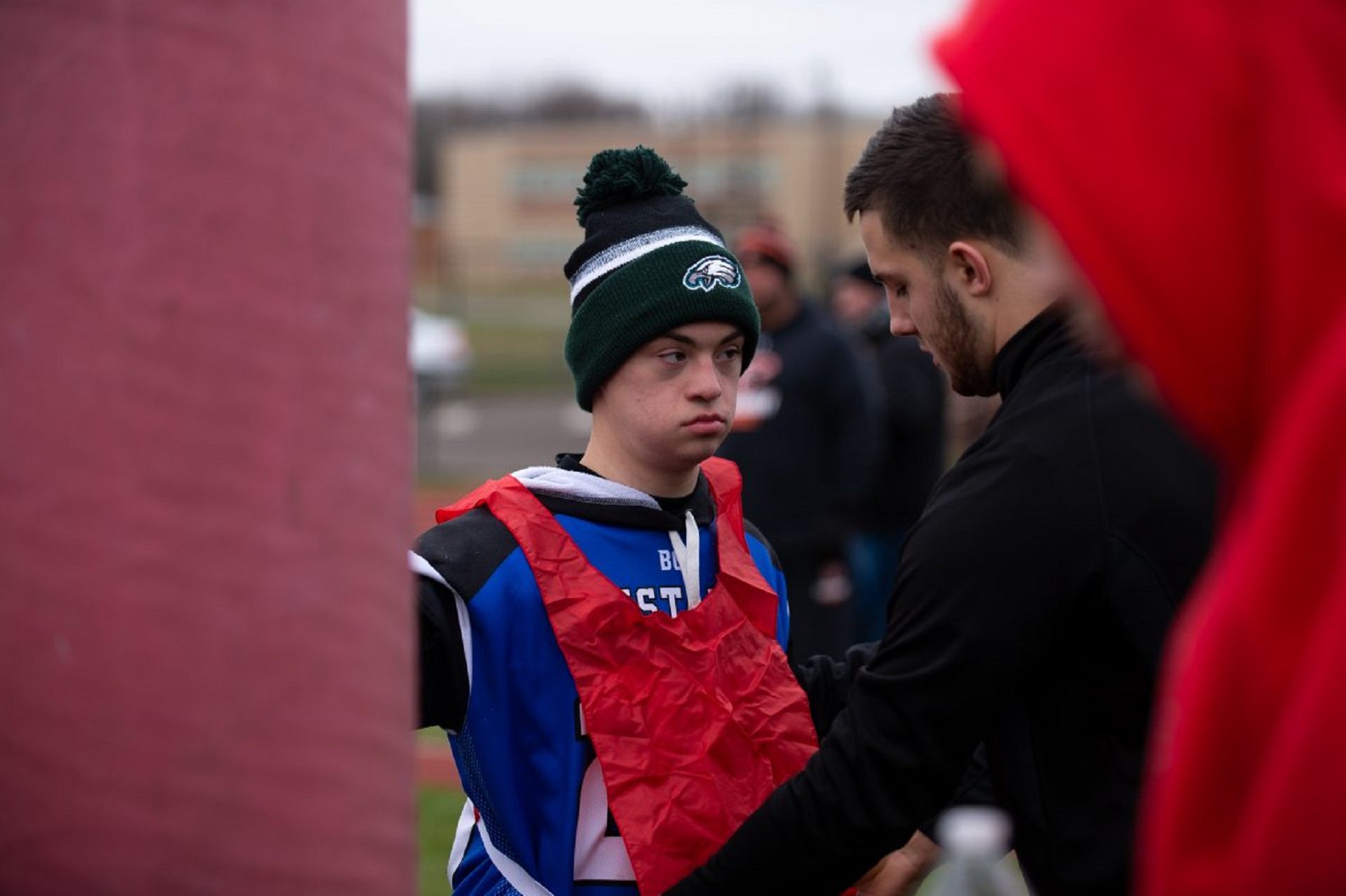 Justin Gabor is helped into a pinny by his buddy, John Hutchinson, during practice at Neshaminy High School. 